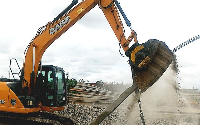 A BF60.1 crusher bucket crushes concrete light poles.