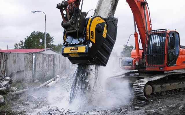 Una benna frantoio BF70.2 frantuma cemento armato e materiale inerte direttamente in cantiere.